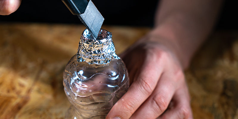 Fjern flaskelåget, og vikl stanniol rundt om toppen af den første flaske Spand-gravity bong: Fjern flaskelåget, og vikl stanniol rundt om toppen af den første flaske