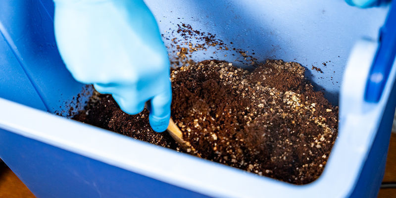 Efter 90 minutter fjernes låget, og indholdet røres for at bryde kokosfibrene op After 90 minutes, remove the lid and stir the contents to break up the coco coir