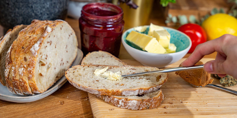 Skær to tykke skiver cannabisbrød med brødkniv og skærebræt Cut Two Thick Slices Of Cannabis Bread Using The Bread Knife And Chopping Board