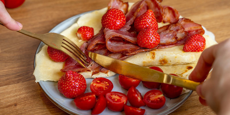 Top dine pandekager med sirup, frisk frugt eller et stykke sprødt bacon ved siden af Top dine pandekager med sirup, frisk frugt eller et stykke sprødt bacon ved siden af