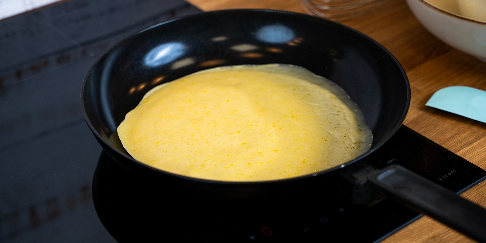 Brug en suppeske til at hælde pandekagedej på panden Use the soup ladle to pour pancake batter into the pan