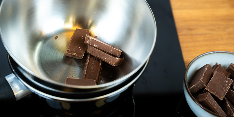 Bræk chokoladen i små stykker Bræk chokoladen i små stykker